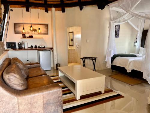 a living room with a couch and a bed at Lapa Lange Game Lodge in Mariental