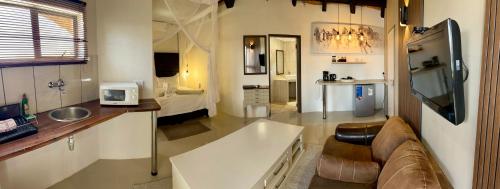 a living room with a couch and a sink in a room at Lapa Lange Game Lodge in Mariental