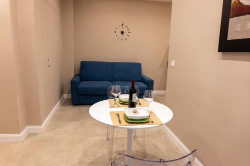 a table with a bottle of wine and a blue couch at Freedom in SantʼAntonio Abate