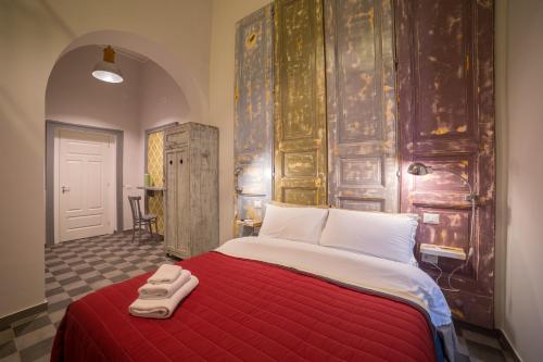 a bedroom with a large bed with a red blanket at The Foria House by House In Naples in Naples