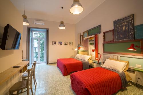 a hotel room with two beds and a television at The Foria House by House In Naples in Naples