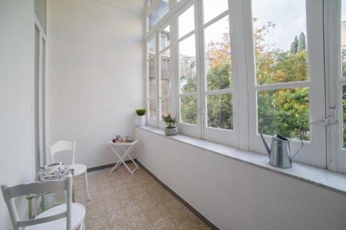 a white room with windows and a table and chairs at The Foria House by House In Naples in Naples