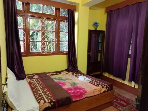 a bedroom with a bed with purple curtains and a window at Hotel Heritage Near Mall Road in Gangtok