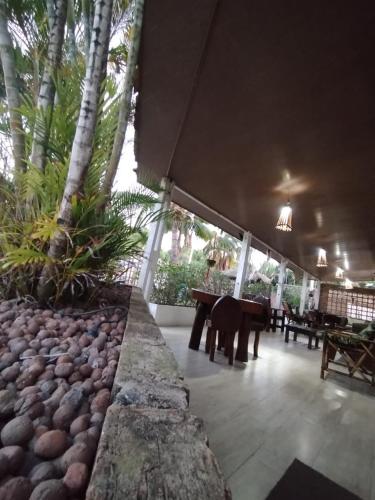 a dining area with a table and rocks and trees at Pousada Sapê in Praia do Frances