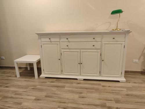 a white cabinet with a green lamp and a bench at San vito 9 in Agrigento