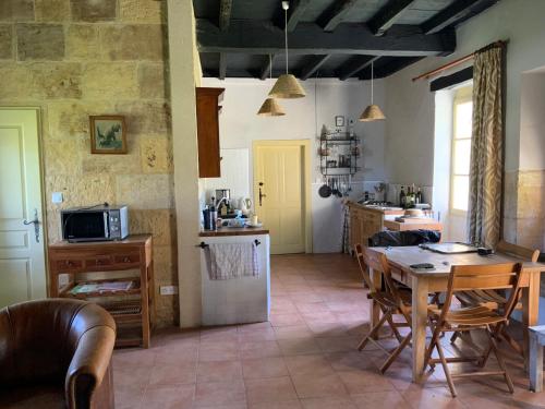 une cuisine avec une table et un réfrigérateur dans l'établissement Bergerie with large swimming pool, à Faux