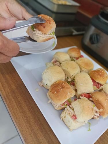 a person holding a plate with sandwiches on it at Ponta Negra Suites & Apart in Natal