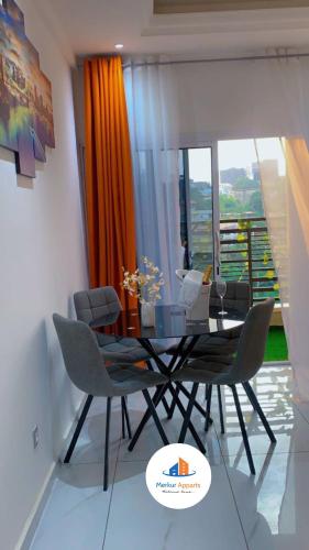 a dining room with a glass table and chairs at Studio meublé haut standing, Titi Garage in Djoungolo