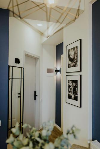 a hallway with two pictures on the wall and a mirror at Luxury Inn Grand Residences in Tbilisi City