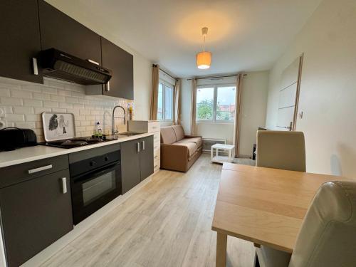 a kitchen and living room with a table and a dining room at Domaine des 5 Roses - Rose Blanche in Vendrennes