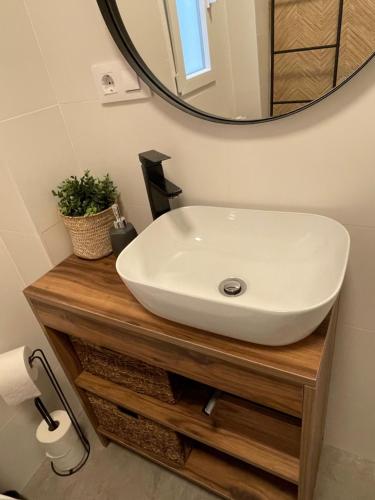 a bathroom with a white sink and a mirror at Apartamento Cambil in Baeza