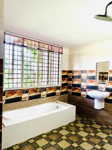 a bathroom with a tub and a sink at Thottungal Homestay in Ernakulam