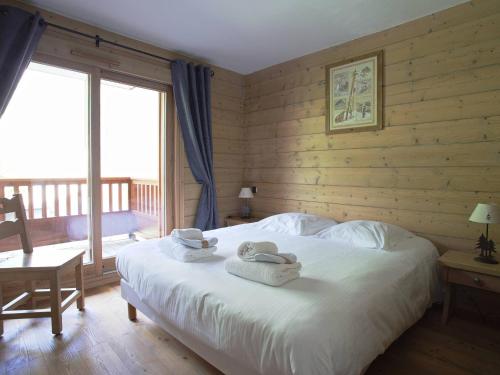 a bedroom with a bed with towels on it at Appart. 3* 5 Flocons Or avec Piscine & Spa, aux pieds des pistes - FR-1-461-15 in Saint-Martin-de-Belleville