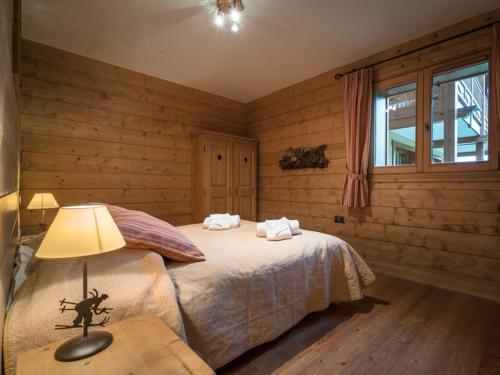 - une chambre avec des murs en bois et un lit avec une lampe dans l'établissement Apt de Standing avec Piscine et Spa, Pied de Pistes, Saint-Martin-de-Belleville - FR-1-461-4, à Saint-Martin-de-Belleville