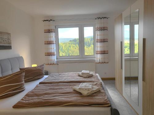 a bed in a room with a large window at FeWo Bergblick - Oberwiesenthal in Kurort Oberwiesenthal
