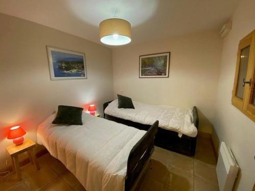 deux lits dans une chambre avec deux lampes dans l'établissement Magnifique T2 58m², centre Chinaillon, proche pistes, balcon ouest, parking, 3 étoiles - FR-1-458-156, au Grand-Bornand