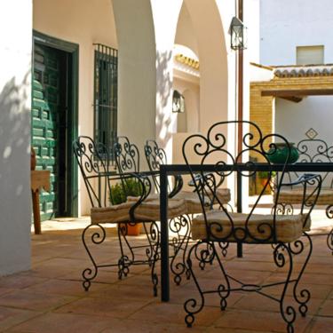 a couple of benches sitting in front of a building at Lince Casa Rural in El Rocío