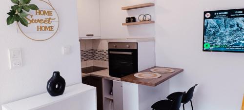 a kitchen with a counter and a table and chairs at Apartman Luka in Trojica
