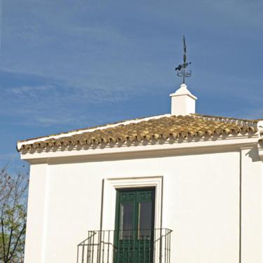 a white building with a window and a weather vane at Lince Casa Rural in El Rocío
