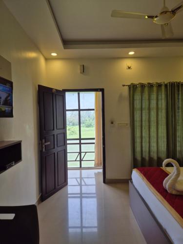 a bedroom with a bed and a door with a window at Alfa Inn in Nedumbassery