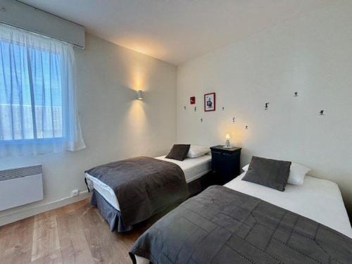 une chambre avec deux lits et une fenêtre dans l'établissement Appartement 3 pièces à Quiberon, vue mer, parking, proche plage et commerces - FR-1-478-298, à Quiberon