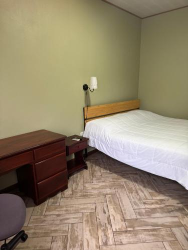 a bedroom with a bed and a desk and a chair at Hotel Vale's in Chiles