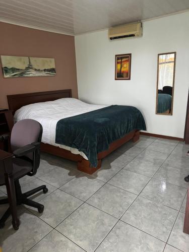 a bedroom with a bed and a desk and a chair at Hotel Vale's in Chiles