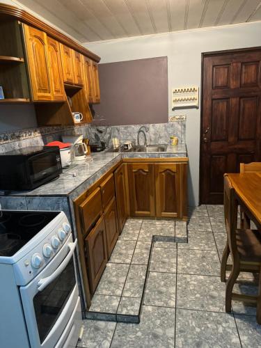 a kitchen with wooden cabinets and a white stove top oven at Hotel Vale's in Chiles
