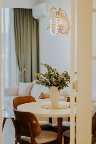 a dining room table with a vase of flowers on it at Luxury Inn Grand Residences in Tbilisi City