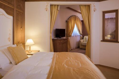 a bedroom with a large bed and a television at Hotel Chalet Del Sogno in Madonna di Campiglio