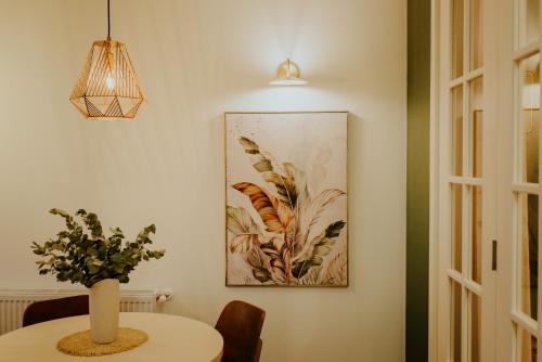a dining room table with a vase of flowers on it at Luxury Inn Grand Residences in Tbilisi City