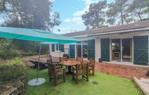 une terrasse avec une table, des chaises et un parasol dans l'établissement Gorgeous Home In Saint-Brevin-Les-Pins, à Saint-Brévin-les-Pins