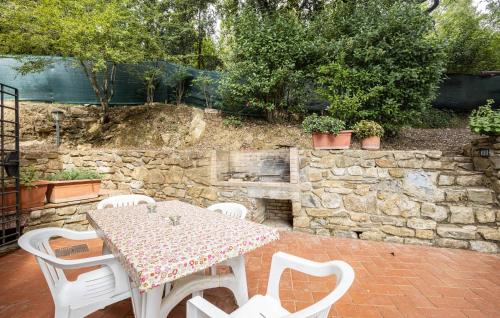 a table and chairs on a patio with a stone wall at Villa Marisa in Monteverdi Marittimo