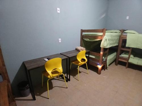a table and two chairs in a room with bunk beds at Maga Inn House - Centro in Blumenau