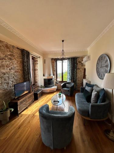 a living room with two couches and a tv at Αρχοντικό Νόνη in Mileai