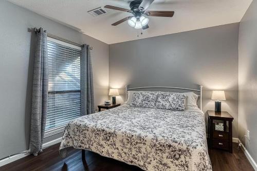 a bedroom with a bed with a ceiling fan and a window at Highland Pointe - Resort Amenities & Hot Tub in Branson
