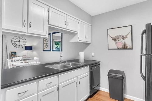 a kitchen with a sink and a cow picture on the wall at Highland Pointe - Resort Amenities & Hot Tub in Branson