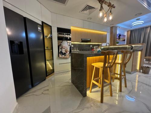 a kitchen with a bar with two stools at Luxury Smart Home- Villa Duplex in Hurghada