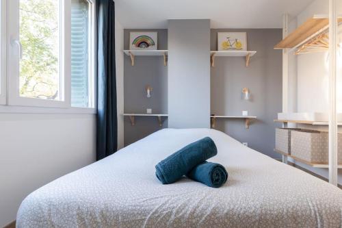 a bedroom with a bed with a blue towel on it at L'aigle, Bel appartement Proche centre et parking in Grenoble