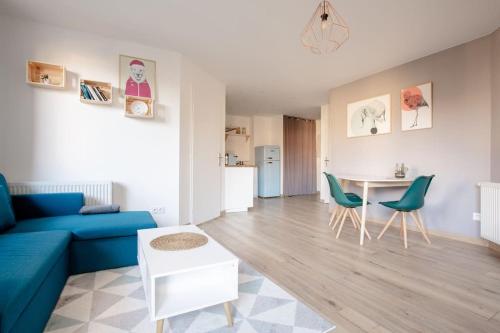 un salon avec un canapé bleu et une table dans l'établissement L'aigle, Bel appartement Proche centre et parking, à Grenoble