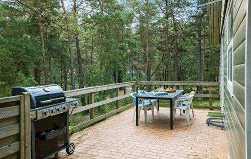 a patio with a grill and a table and chairs at Fyrrebakken in Spidsegård