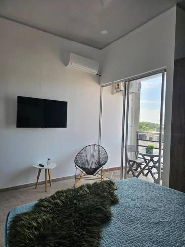 a bedroom with a bed and a television and a chair at Disfruta el encanto llanero in Granada