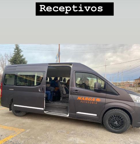 a gray van parked in a parking lot with people inside at Hotel Picos Del Sur in El Calafate