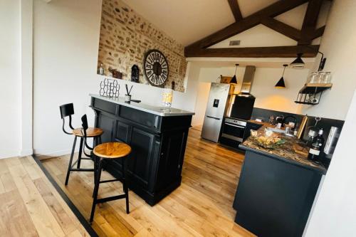 - une cuisine avec un îlot noir dans la chambre dans l'établissement Le Perchoir- Vue imprenable sur ville - Wifi, à Perpignan