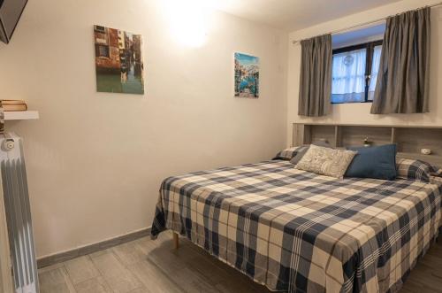 a bedroom with a bed with a plaid blanket at Casa Pina B&B in Spoltore