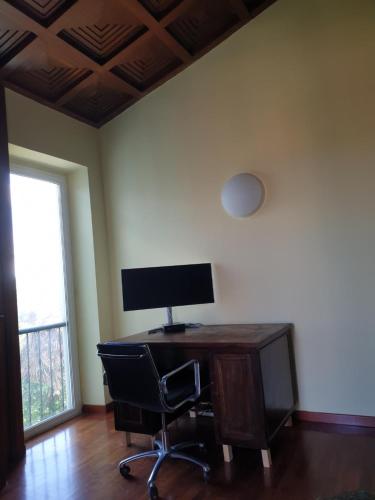 a computer desk with a monitor and a chair in a room at Guest House G & G in Castelnuovo di Porto