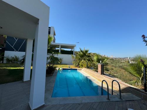 una piscina en el patio trasero de una casa en Isıtmalı Havuzlu Lüks Villa, en Kusadasi