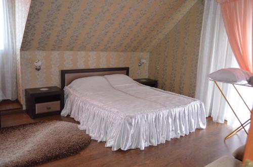 a bedroom with a bed with a white bedspread at Hotel Fiyesta in Starokostyantyniv