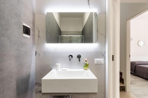 a bathroom with a white sink and a mirror at Don Camillo Maison in Avola