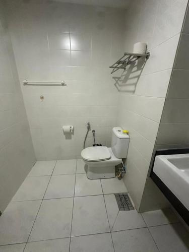 a white bathroom with a toilet and a sink at Jasmine Studio Trefoil in Setia Alam